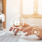 Person hands typing on a laptop with lock icons to demonstrate cybersecurity for government