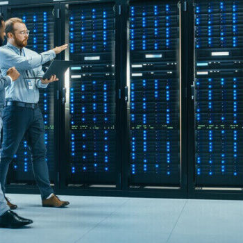 Technicians in server room discussing cybersecurity trends